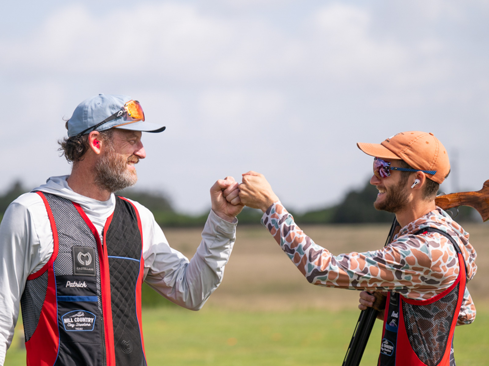 Shooters trading a fist bump at a charity clay shoot